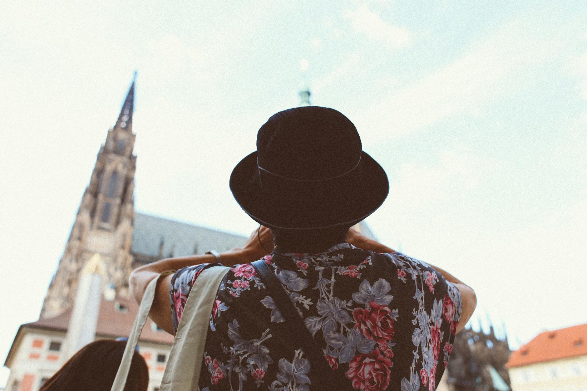 Turysta w kwiecistej koszuli fotografuje zabytkowy kościół