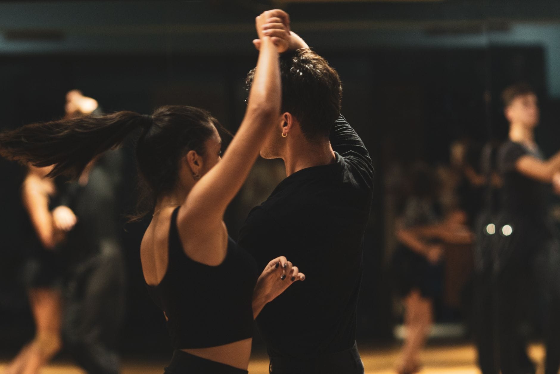 Para tańcząca tango w studiu tanecznym wśród obserwujących