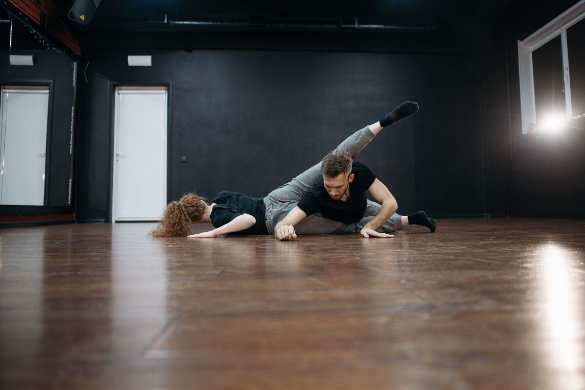 Skuteczny trening izolacji w tańcu: od podstaw do płynnych sekwencji Para tancerzy wykonuje współczesną choreografię w sali z drewnianą podłogą