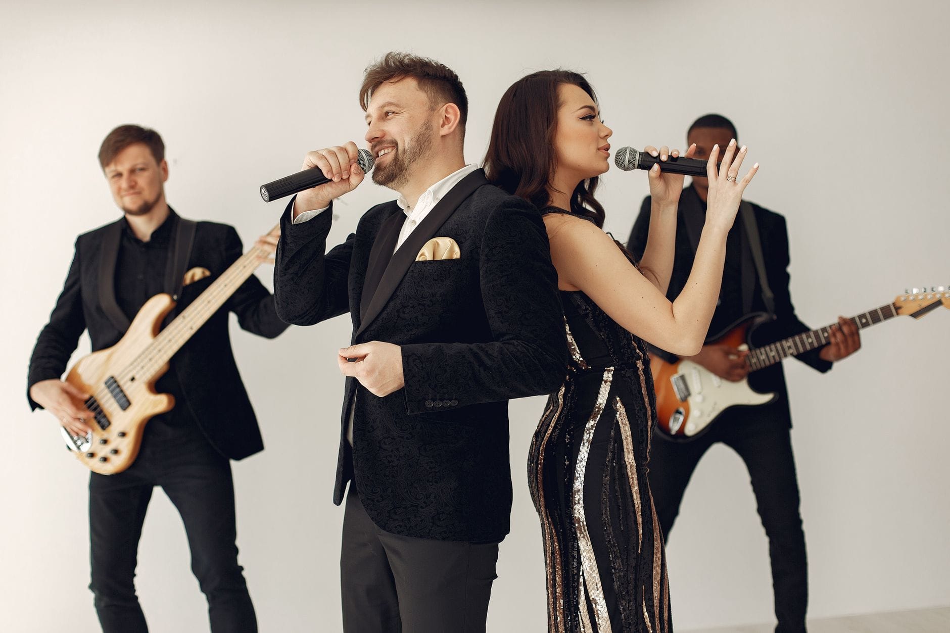 Zespół weselny z wokalistami występuje na scenie w dynamicznej pozie